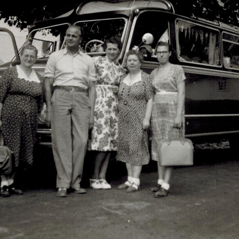 viele Leute vor einem alten Omnibus