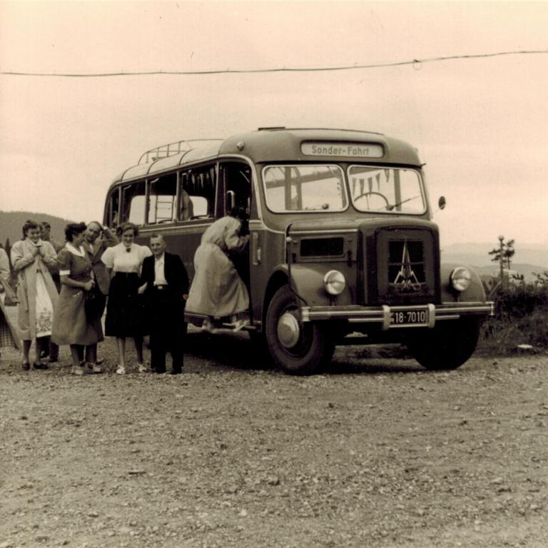 Leute steigen in einen alten Bus ein
